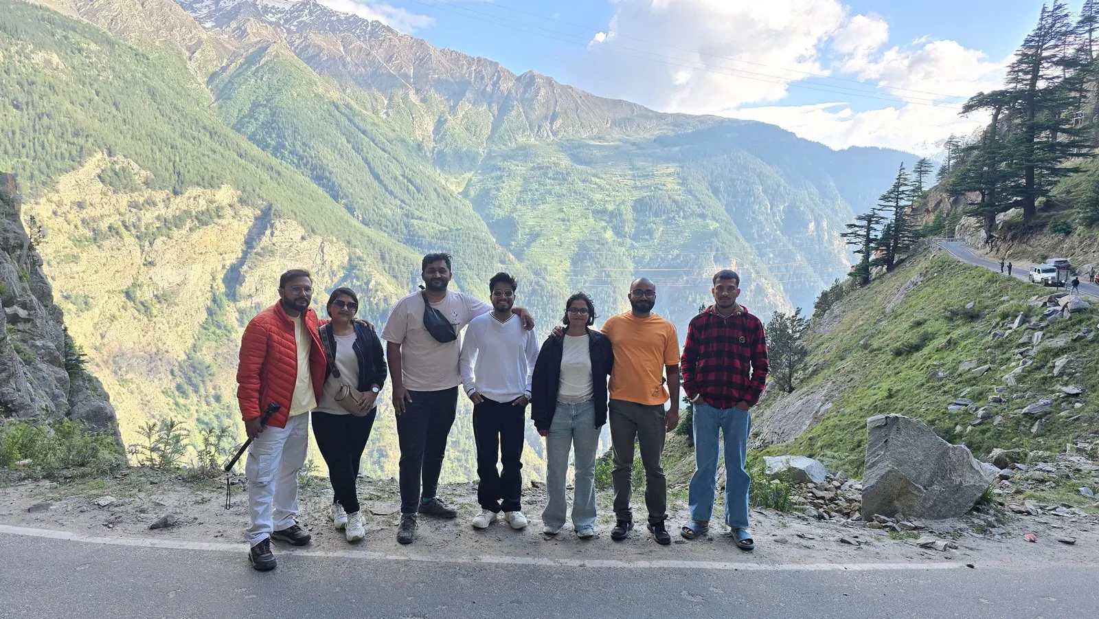 A group of travelers together at Suicide Point, Kalpa, overlooking the green valley